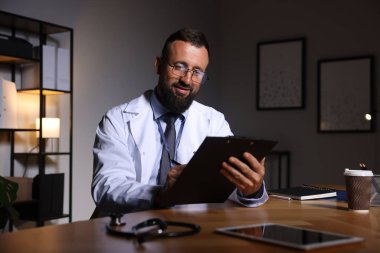 Doktor, gece vardiyası sırasında klinikteki masada notlar yazıyor.