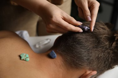 Kristal terapi gören bir adam aurasını kapalı alanda iyileştirmek ya da yenilemek için, yakın çekim