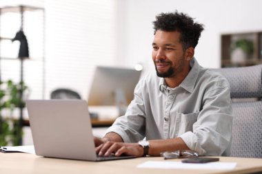 ofiste masada dizüstü bilgisayarda çalışan adam