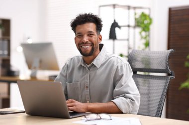 ofiste masada dizüstü bilgisayarda çalışan adam