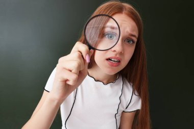 Okula dönelim. Kapalı alanda elinde büyüteç olan öğrenci.