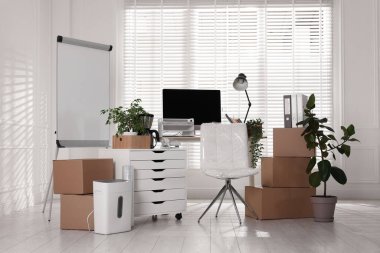 Taşınma günü. Mukavva kutular, bilgisayar ve mobilyalar ofiste.
