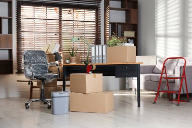 Yeni ofiste birçok taşınan kutu, ev bitkisi, merdiven ve mobilya