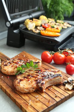 Lezzetli ızgara biftekler ve sebzeli elektrikli ızgara.