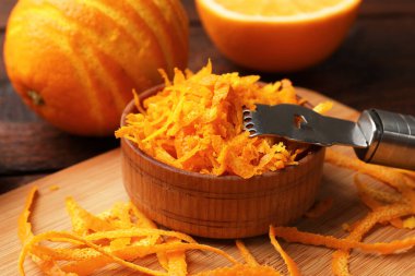 Portakal tadı, taze meyve ve zester aleti ahşap masada, yakın plan.