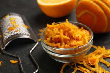 Portakal tadı, taze meyve ve rende siyah masada, yakın plan.