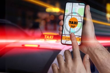 Şehir caddesinde taksi çağırmak için cep telefonu uygulaması kullanan bir adam.