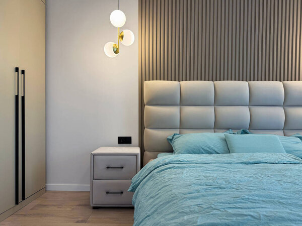 Стильный интерьер спальни с удобной большой кроватью и светящимися лампами