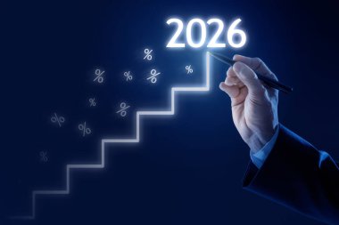 Sanal ekranda 2026 rakamla en üst noktayı gösteren iş adamı koyu mavi arka planda yüzde işaretleri olan, yakın plan. Yeni yıl hedefleri ve planları
