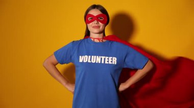 Sarı arka planda süper kahraman kostümü giyen gönüllü.