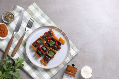 Gri masada servis edilen lezzetli ızgara sebzeli şişler. Metin için boşluk
