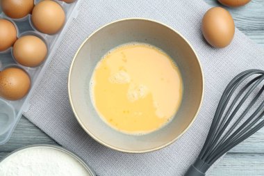 Tabakta çırpılmış yumurtalar, çırpılmış çırpılmış un masada, düz yatıyordu.