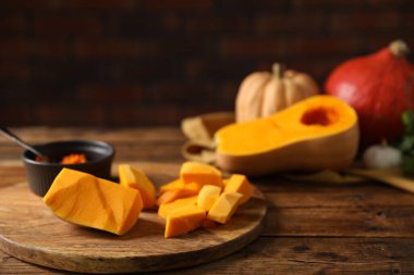 Taze balkabakları ve tohumlar ahşap masada tuğla duvara karşı, yakın plan.