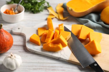 Balkabağını, bıçağını, baharatını ve tohumlarını açık ahşap masada kes. Yakın plan.