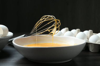 Kavanozda çırpılmış yumurtalar ve koyu ahşap masada çırpılmış çırpılmış çırpılmış çırpılmış çırpılmış, yakın plan.