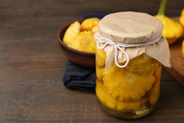 Ahşap masada cam kavanozda pattypan kabağı turşusu, yakın plan. Metin için boşluk