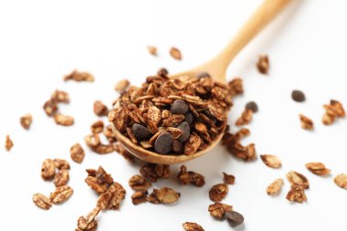 Beyaz arka planda çikolata parçalı lezzetli granola, yakın plan.