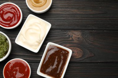 Tabaklardaki farklı soslar ahşap masada, düz yerde. Metin için boşluk