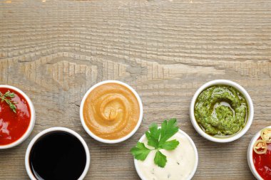 Ahşap masada farklı soslar ve maydanoz var. Metin için boşluk