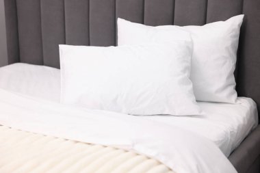 Temiz çarşafları olan büyük bir yatak, yakın plan.