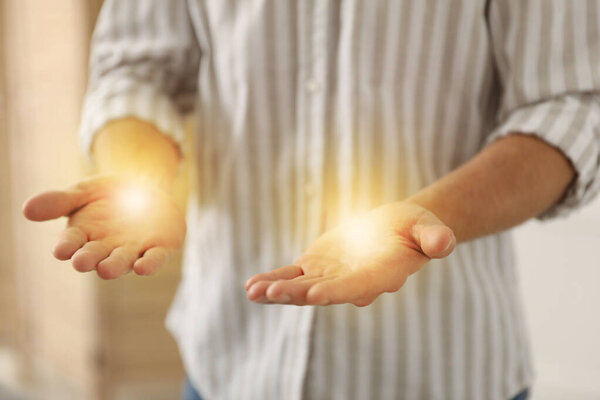 Aura concept. Reiki master showing his hands indoors, closeup