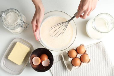 Beyaz masada hamuru yapan kadın (sıvı hamur), üst görünüm