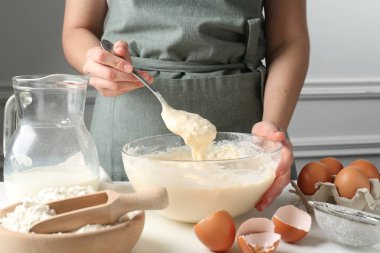 Beyaz masada hamuru hazırlayan kadın, yakın plan.