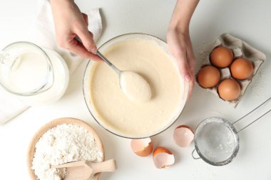 Beyaz masada hamuru yapan kadın (sıvı hamur), üst görünüm