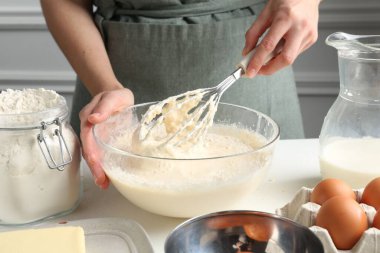Beyaz masada hamuru hazırlayan kadın, yakın plan.