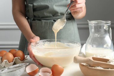 Beyaz masada hamuru hazırlayan kadın, yakın plan.