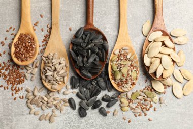 Gri masadaki kaşıklarda farklı tohumlar, düz yatıyordu.