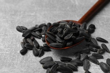 Kaşık içinde ayçiçeği tohumları Gri masada, yakın plan