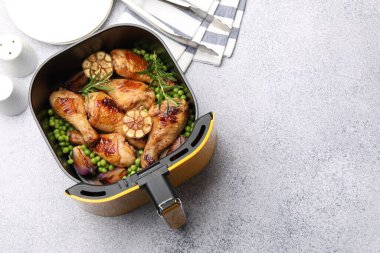 Izgara tavuk budu, baharat, yeşil bezelye ve maşayla servis edilen tavuklu kızartma sepeti. Metin için boşluk