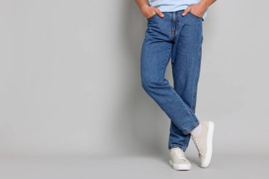 Açık gri arka planda şık kotlu bir adam, yakın plan. Metin için boşluk