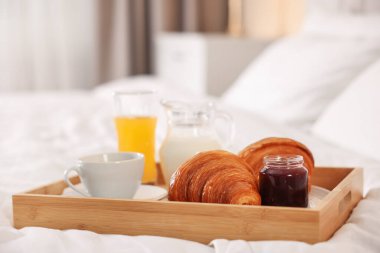 Otel odasındaki yatakta nefis bir kahvaltı tepsisi, yakın plan. Metin için boşluk