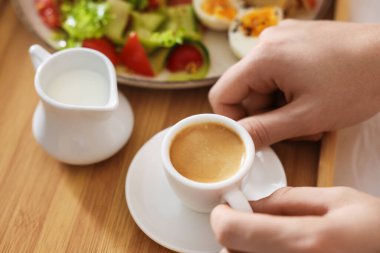 Yatakta kahvaltı yapan bir adam, yakın plan. Otel oda servisi.