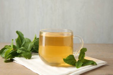 Tahta masada bir fincan lezzetli çay ve nane şekeri. Metin için boşluk