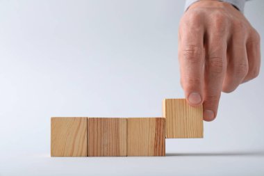 Hafif arka planda tahta küpleri olan adam, yakın plan. Metin için boşluk