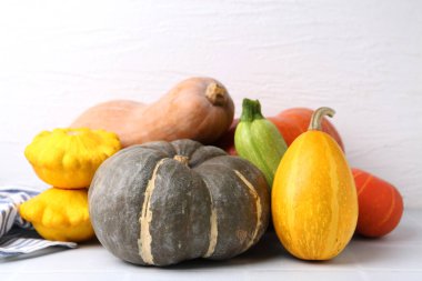 Birçok taze balkabağı ve diğer sebzeler açık fayanslı masada, yakın plan.