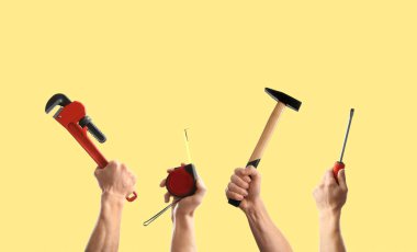 Soluk turuncu arka planda farklı aletler tutan insanlar, yakın plan. Kolaj