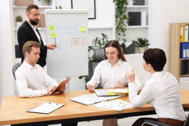 İş süreci. Meslektaşlar ofiste strateji tartışıyor