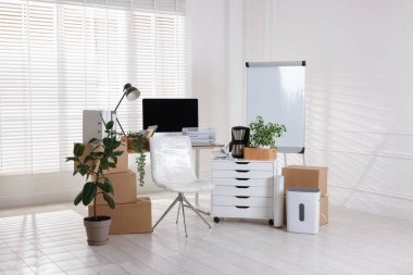 Taşınma günü. Mukavva kutular, bilgisayar ve mobilyalar ofiste.