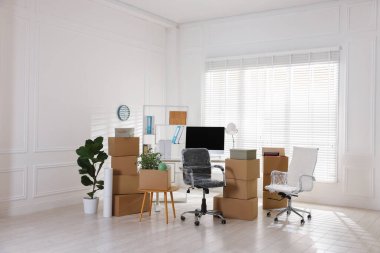 Taşınma günü. Mukavva kutular, bilgisayar ve mobilyalar ofiste.