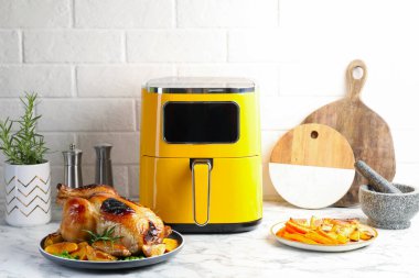 Lezzetli ızgara tavuk biberiyeli, sebzeli ve beyaz mermer masada kızartma makinesi.