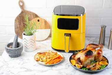 Lezzetli ızgara tavuk biberiyeli, sebzeli ve beyaz mermer masada kızartma makinesi.