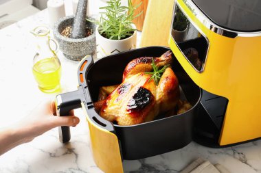 Beyaz mermer masada tavuk ve sebze pişiren kadın, yakın plan.