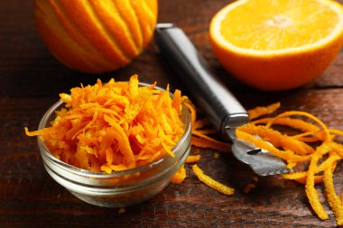 Portakal tadı, taze meyve ve zester aleti ahşap masada, yakın plan.