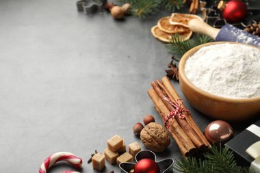 Noel sezonu. Kurabiye malzemeleri, mutfak gereçleri, baharatlar ve dekorlar gri masada, yakın plan. Metin için boşluk