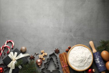 Noel sezonu. Kurabiye malzemeleri, mutfak gereçleri, baharatlar ve dekorlar gri masada, düz yerde. Metin için boşluk