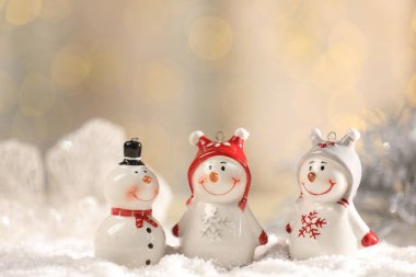 Yapay kar üzerinde sevimli kardan adamlar bulanık arka planda, yakın plan